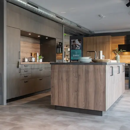 Küche mit Kochinsel aus Holz, Spüle, Arbeitsplatte und Schränken im Showroom